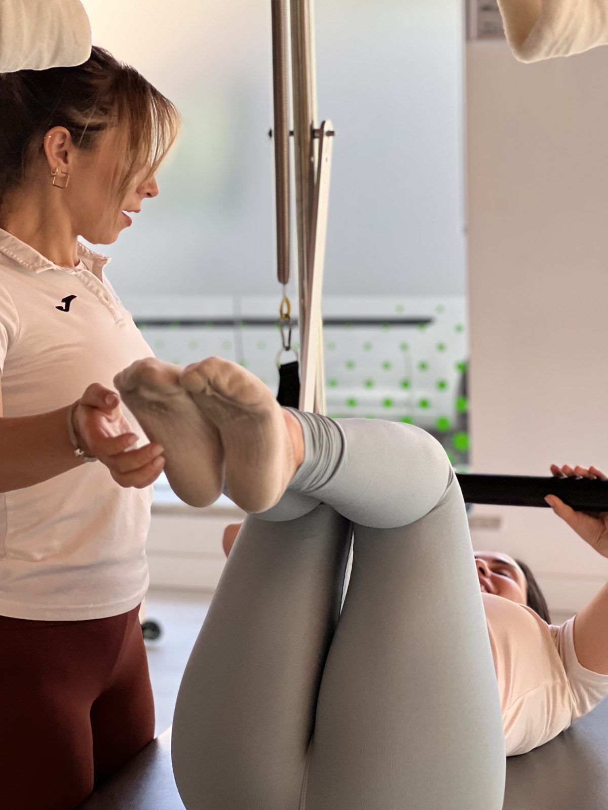 Instrutora da AtiveFit a acompanhar uma cliente num exercício no Cadillac