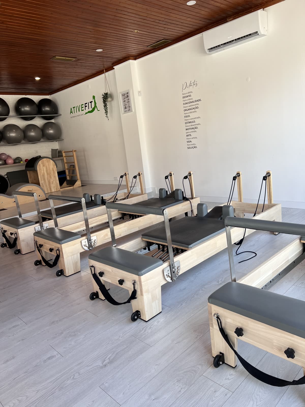 Estúdio da AtiveFit em São Romão, Leiria, com os reformers e a parede de citações sobre Pilates